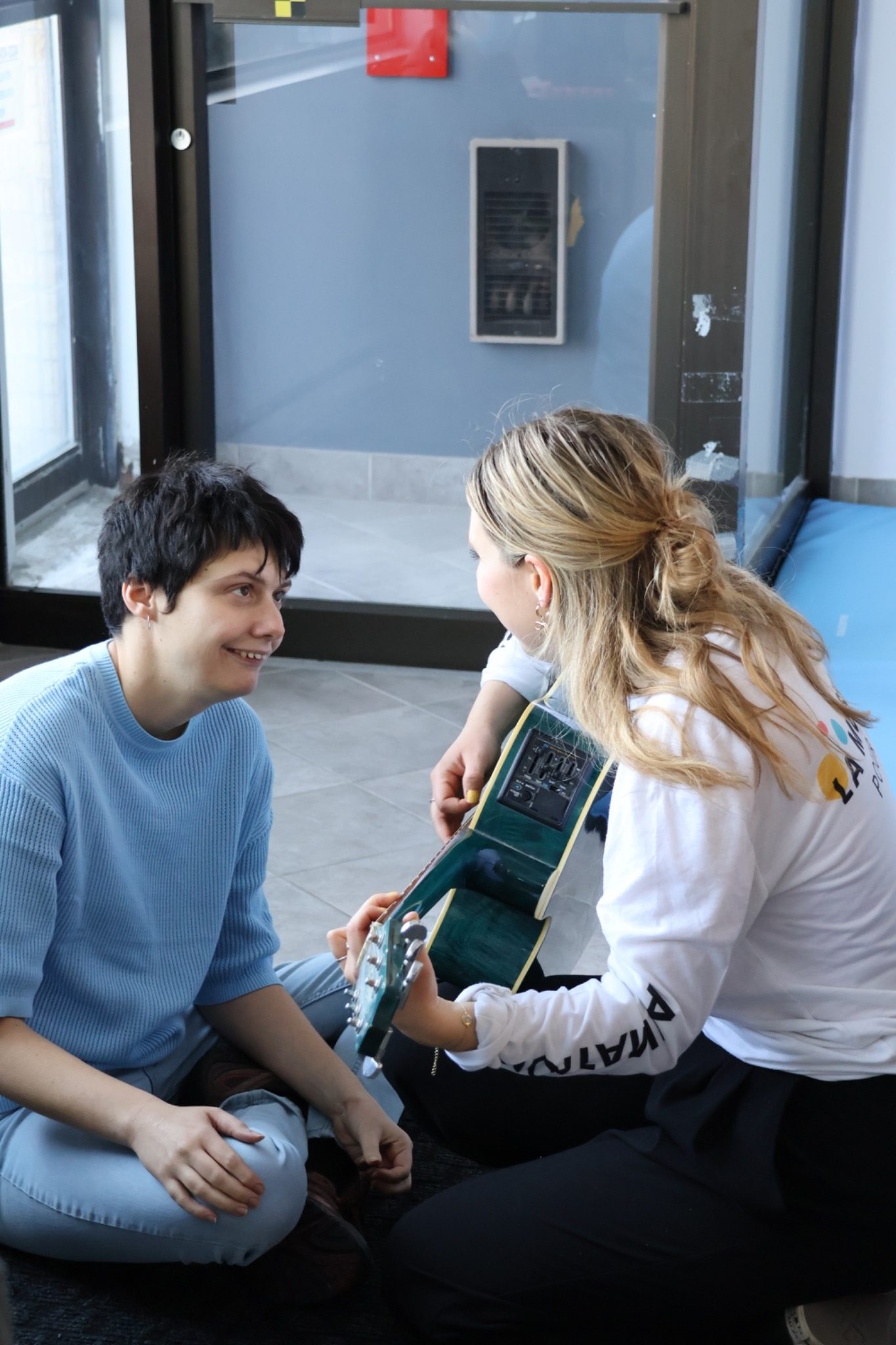 Animatrice accompagnant un participant à besoins particuliers en musique